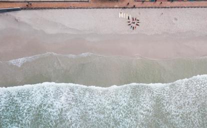 Projects Abroad vrijwilligers geven surfles aan lokale kinderen op het surf project in Kaapstad, Zuid-Afrika Surf project vrijwilligers werken met de lokale kinderen in Zuid-Afrika
